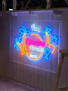 a neon sign on the side of a building that says bar coquinine paradise beach