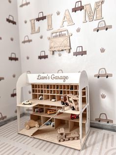 a wooden toy car garage with cars and trucks on the wall in front of it