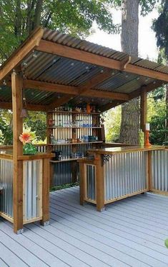 an outdoor bar made out of metal and wooden planks with bars on the top