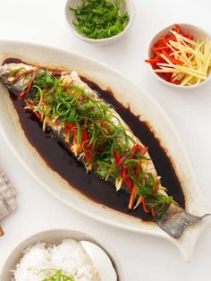 an image of fish with sauce and vegetables on the side for garnishes