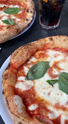 two pizzas sitting on top of white plates