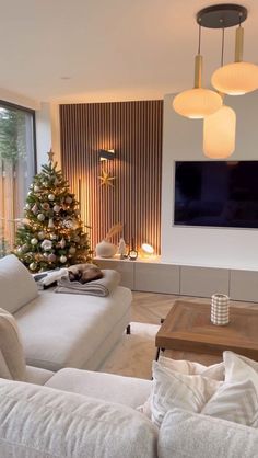 a living room filled with furniture and a christmas tree in front of a flat screen tv