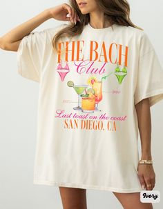 a woman wearing a t - shirt that says the beach club