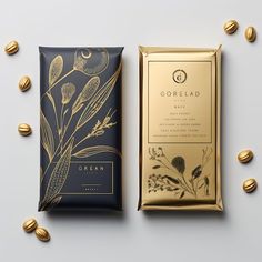 two bars of chocolate next to each other on a white surface with gold foil around them