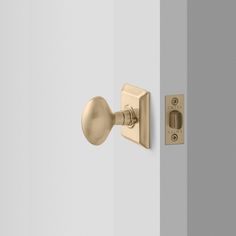 an open door with a handle and knob on the outside wall, in front of a light gray wall