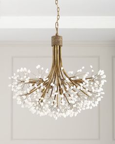 a chandelier with white flowers hanging from it's ceiling fixture in a room