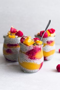 three glasses filled with chia pudding topped with raspberries and pineapples