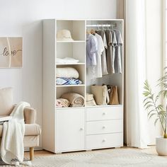 a white closet with clothes on it and a couch in the room next to it