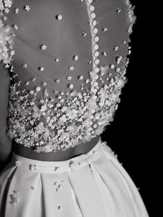 a black and white photo of a woman wearing a dress with sequins on it