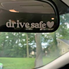 drive safe sticker on the side mirror of a car with trees in the background