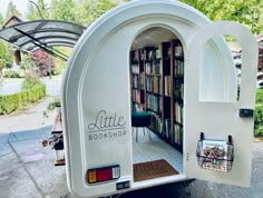 the little book shop is parked on the side of the road with its doors open