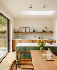 a kitchen with an island table and wooden chairs