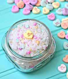 a jar filled with lots of white and pink sprinkles on top of a blue table