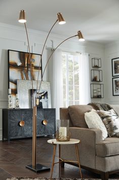 a living room with a couch, chair and floor lamp in it's center