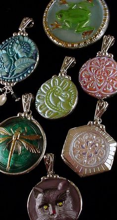 six pendants with different designs and animals in them on a black background, one has a dragonfly