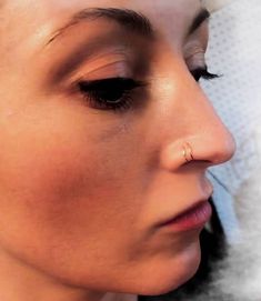 a close up of a woman with nose piercings on her left side and right side of the face