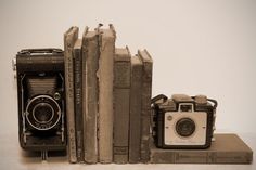 an old camera and some books on a table