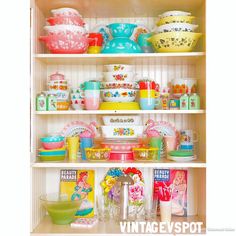 the shelves are filled with colorful dishes and bowls