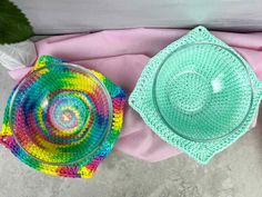 two glass bowls sitting on top of a pink blanket next to a potted plant