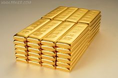 a stack of gold bars sitting on top of a white table next to each other