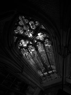 black and white photograph of an old church with stained glass windows in the middle of it