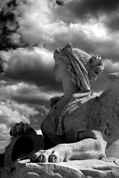 an angel statue sitting on top of a rock