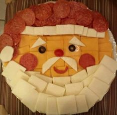 a plate with cheese and meats in the shape of a man's face