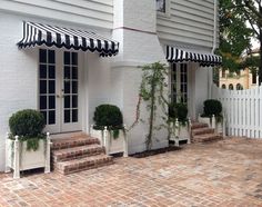 a white house with black and white awnings