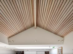 the interior of a modern house with wood slats on the ceiling and white walls