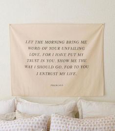 a bed with pillows and a wall hanging above it that says let the morning bring me word of your unfailing love for i have put my trust in you show me the way i should