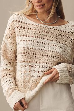 a woman is wearing a white sweater with crochet