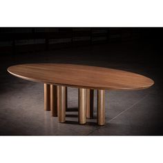 an oval wooden table with four columns around it