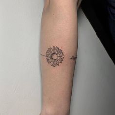 a woman's arm with a flower tattoo on the left side of her body