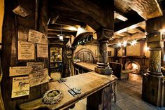 the inside of a building with wooden floors and walls, including an old fashioned fireplace