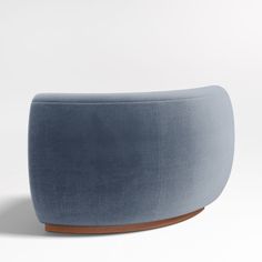 an upholstered blue ottoman with wooden feet