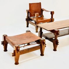 three chairs and a table made out of wood with leather seats on each one side