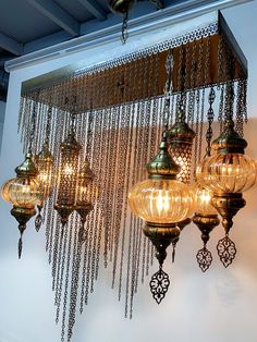 a chandelier hanging from the ceiling in a room with many lights on it