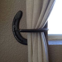 the curtain rod is hanging on the wall by the window with it's black handle