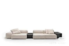 two couches with pillows sitting next to each other on a white surface, one is black and the other is beige