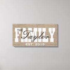 a family name sign hanging on the side of a wall in front of a vase