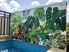 a mural on the side of a building next to a swimming pool with plants painted on it