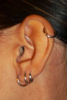 a close up of a persons ear with two silver rings on the end of it