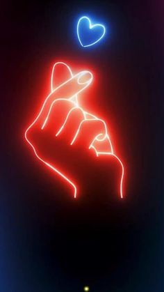 a neon sign that says love is in the air with a hand holding a heart