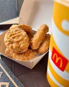 some fried food in a white bowl next to a mcdonald's cup