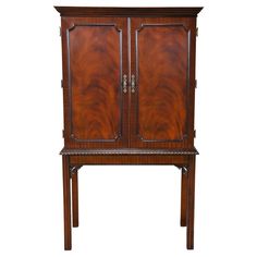 an antique wooden cabinet with two doors and one drawer on the bottom, against a white background