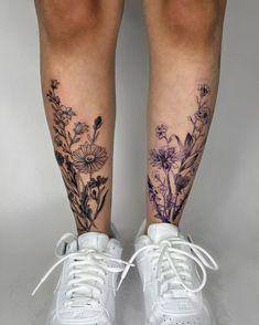 a woman's legs with tattoos on them and flowers in the bottom part of her leg