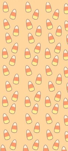 an orange and yellow wallpaper with small candy corns on the bottom right corner