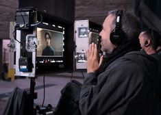 a man sitting in front of a camera with headphones on