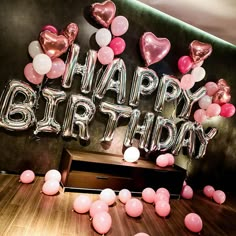 balloons and streamers in the shape of hearts are on display at a birthday party