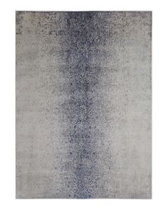 an area rug with grey and blue tones on the floor, in front of a white background